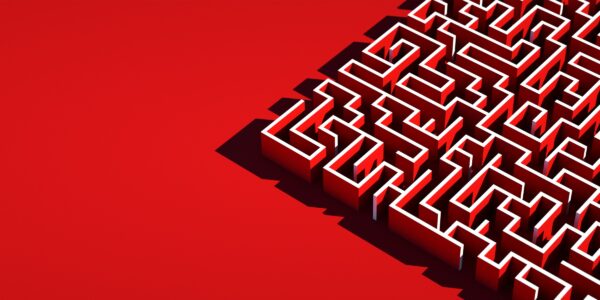 A 3D white maze casts black shadows on a vibrant red background, occupying the right side. The maze evokes complexity and challenge.